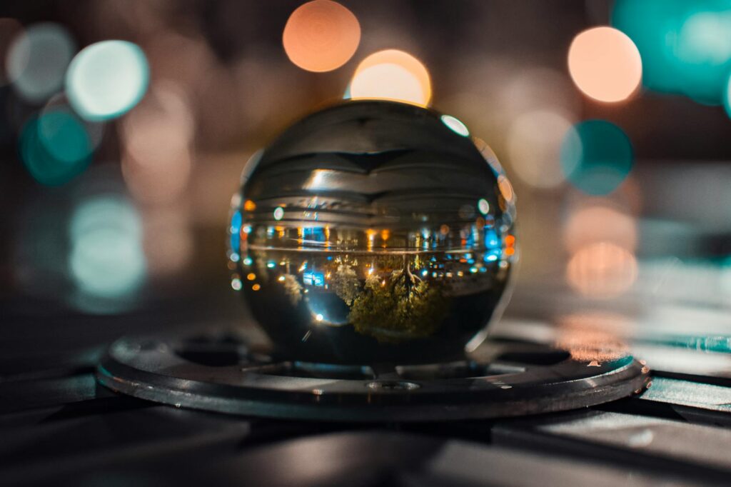 A glass sphere reflects vibrant city lights with a dreamy bokeh effect.